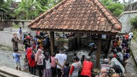 Warga tampak menonton kegiatan pembersihan sendang. 