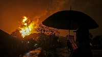 Warga menonton kobaran api yang terlihat di Kilang Pertamina Internasional (KPI) RU IV Cilacap, Jawa Tengah, Minggu (14/11/2021) dini hari.