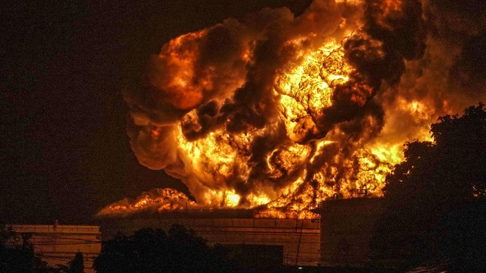 Warga menonton kobaran api yang terlihat di Kilang Pertamina Internasional (KPI) RU IV Cilacap, Jawa Tengah, Minggu (14/11/2021) dini hari. Tangki 36 T 102 terbakar pada Sabtu (13/11/2021) pukul 19.10 WIB itu berisi komponen pertalite. ANTARA FOTO/Idhad Zakaria/foc.