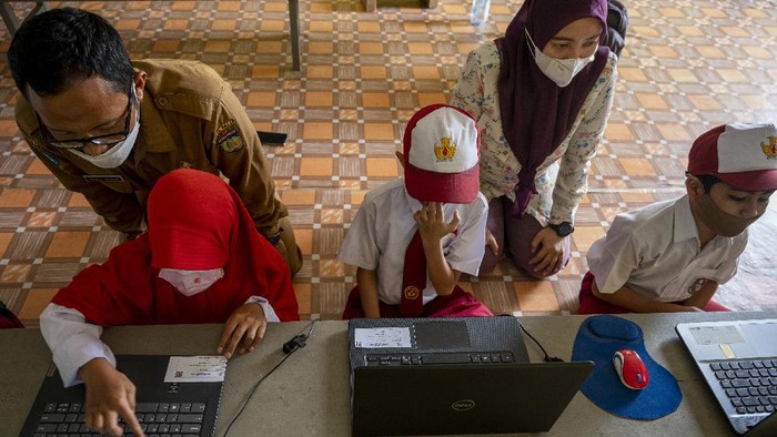 Sejumlah murid dibimbing gurunya mengikuti Asesmen Nasional Berbasis Komputer (ANBK) di sekolah darurat bencana SD Inpres Balaroa, Palu, Sulawesi Tengah, Senin (18/10). Meskipun dalam kondisi yang sangat terbatas, namun sekolah tersebut tetap melaksanakan ANBK yang bertujuan untuk mengukur kualitas kegiatan-belajar mengajar di sekolah. ANTARA FOTO/Basri Marzuki/hp.