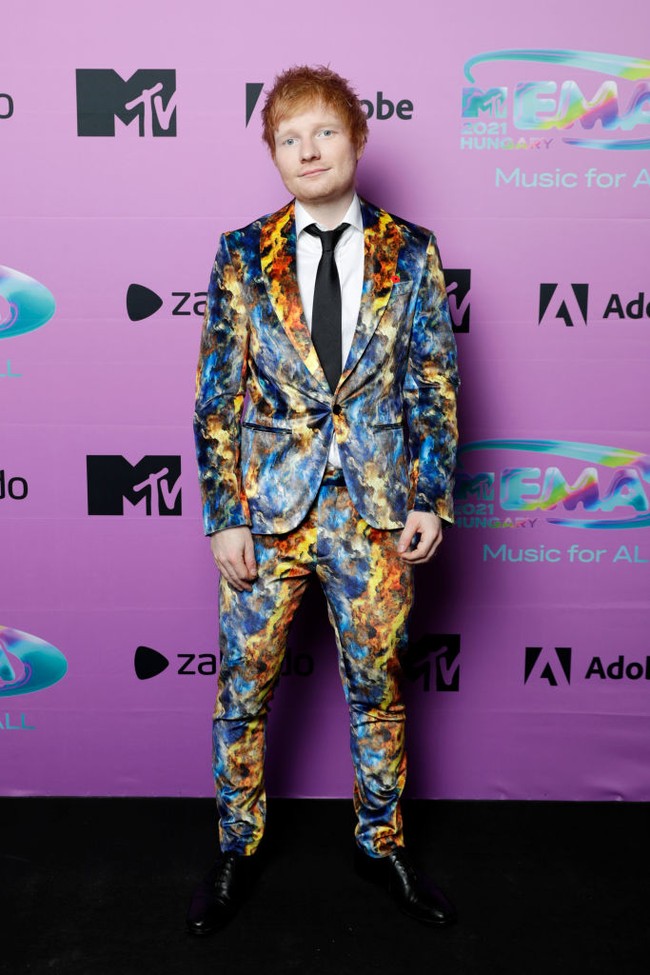 MTV EMAs 2021 yang digelar di Budapest, Hungaria, Minggu (14/11/2021), bertaburan bintang. Penyanyi Ed Sheeran tak ketinggalan. Namun, ada yang berbeda dari penampilannya. Biasa tampil cuek dengan t-shirt, pelantun Shape of You itu kini berbalut setelan berdasi dengan motif abstrak yang terlalu mencolok. (Foto: Getty Images for MTV/Kate Green)