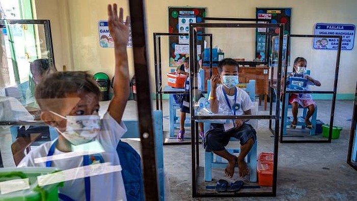 Daerah Alaminos di Filipina gelar sekolah tatap muka usai 2 tahun menerapkan sekolah dari rumah. Para siswa belajar di bilik plastik guna cegah penularan Corona