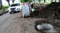 Sebuah mobil melintas di samping proyek pembangunan sumur resapan di kawasan Perumahan Cipinang Indah, Jakarta Timur, Senin (15/11/2021).