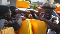 Warga berdatangan membawa jerigen dan berdesak-desakan demi mendapatkan BBM di salah satu pom bensin yang ada di Port-au-Prince, Ibu Kota Haiti, Minggu (14/11/2021) waktu setempat. AP Photo/Odelyn Joseph.