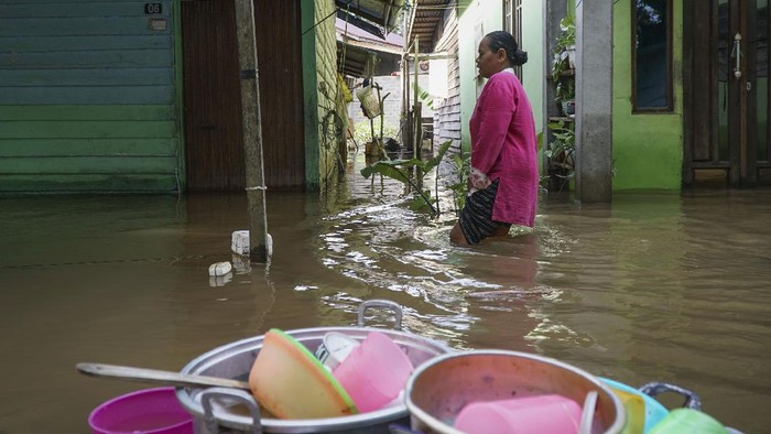 Warga berjalan di depan rumahnya yang terendam banjir di Baning Kota, Kabupaten Sintang, Kalimantan Barat, Senin (15/11/2021). Banjir yang berlangsung hampir empat pekan tersebut berdampak pada terhambatnya roda perekonomian setempat dan aktivitas warga sehari-hari. ANTARA FOTO/Abraham Mudito/app/foc.