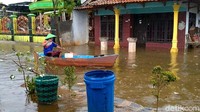 Warga beraktivitas dengan rakit di tengah banjir.