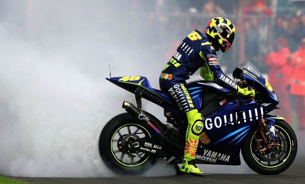 DONINGTON, ENGLAND - JULY 25:  Valentino Rossi of Italy burns rubber after winning the British Grand Prix during the Cinzano British Grand Prix at Donington Park on July 24, 2004 in Donington, England.  (Photo by Jamie McDonald/Getty Images)