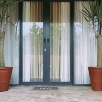 Pintu full-kaca menyumbangkan kesan modern pada rumah ini. (Foto: Instagram Arya Saloka)