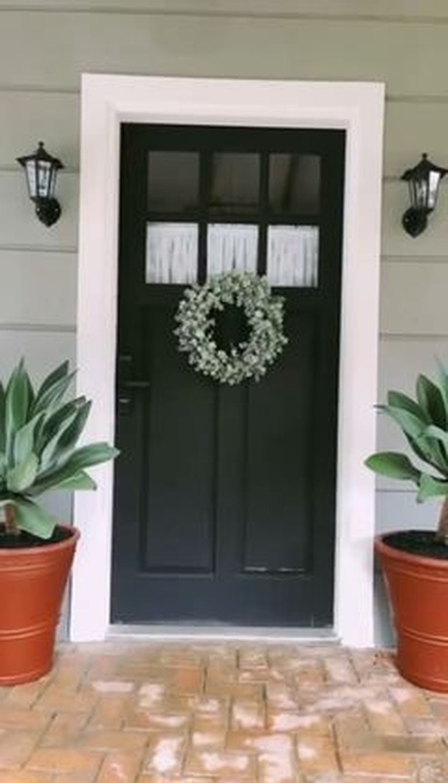 Pintu kayu dengan aksen kaca menjadi pilihan Arya Saloka dan istrinya untuk bagian depan. Pintu dicat berwarna gelap, tapi tetap terlihat manis berkat tanaman hias berbentuk lingkaran yang menggantung di depannya. (Foto: Instagram Arya Saloka)