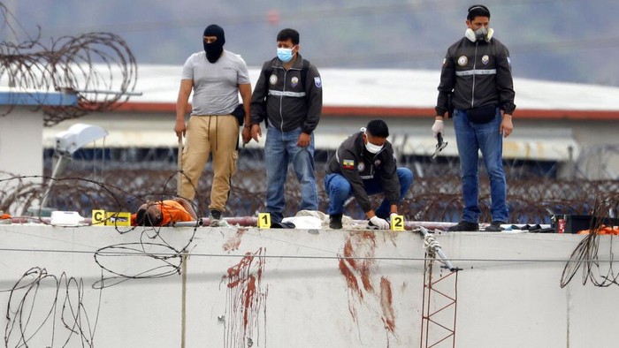 Baku Tembak Geng Narkoba Tewaskan 68 Napi di Penjara Ekuador Bus commuters drive past empty coffins outside the city morgue in Guayaquil, Ecuador, Monday, Nov. 15, 2021. Late Friday, a brutal attack was launched inside the Litoral penitentiary and clashes among rival gangs lasted for hours into early Saturday, leaving at least 68 inmates dead. (AP Photo/Dolores Ochoa)