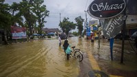Warga menorobos banjir yang merendam permukiman di Kecamatan Barabai, Kabupaten Hulu Sungai Tengah, Kalimantan Selatan, Selasa (16/11/2021). Presiden Joko Widodo (Jokowi) berbicara soal banjir di Kalimantan pada Selasa (16/11/2021). Jokowi mengatakan banjir di Kalimantan terjadi akibat kerusakan daerah tangkapan hujan. ANTARA FOTO/Bayu Pratama S  