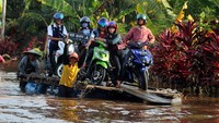 Dampak dari banjir yang merendam ruas jalan nasional menuju wilayah timur Kalbar itu membuat warga setempat berinisiatif membuat rakit untuk menyeberangkan para pengendara motor yang ingin melintasi banjir tersebut dengan bayaran seikhlasnya. ANTARA FOTO/Jessica Helena Wuysang  
