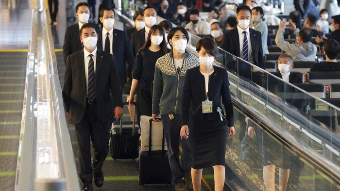 Mako Komuro, former Princess Mako, and Kei Komuro, right, arrive at John F. Kennedy International Airport in the Queens borough of New York Sunday, Nov. 14, 2021. The Japanese princess who gave up her royal status to marry her commoner college sweetheart arrived in New York on Sunday, as the couple pursued happiness as newlyweds and left behind a nation that has criticized their romance. (Kyodo News via AP)