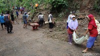 Warga membersihkan material longsor yang menutup akses jalan kabupaten di kawasan Bukit Menoreh, Kulon Progo, Daerah Istimewa Yogyakarta (DIY), Selasa (16/11/2021).
