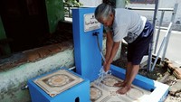 Seorang warga mencuci tangan di tempat cuci tangan dan bersuci gratis di Desa Jatipuro, Kecamatan Trucuk, Klaten, Jawa Tengah, Rabu (17/11/2021).