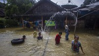Sejumlah anak bermain di sekitar rumahnya yang terendam banjir di Kecamatan Barabai, Kabupaten Hulu Sungai Tengah, Kalimantan Selatan, Rabu (17/11/2021).