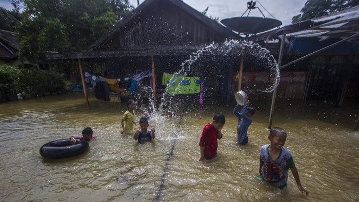 Seorang warga menuntun sepedanya melewati banjir di Desa Pajukungan, Kabupaten Hulu Sungai Tengah, Kalimantan Selatan, Rabu (17/11/2021). Sejumlah wilayah di Kabupaten Hulu Sungai Tengah masih terendam banjir dan warga merasa khawatir jika terjadi banjir susulan saat hujan deras kembali terjadi. ANTARA FOTO/Bayu Pratama S/tom.