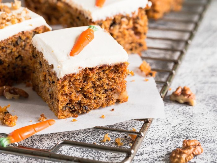 pieces of carrot cake with walnuts with icing cream on a light background. tinting. selective focus/