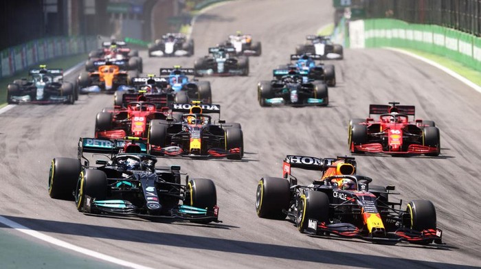 SAO PAULO, BRAZIL - NOVEMBER 14: Max Verstappen of the Netherlands driving the (33) Red Bull Racing RB16B Honda and Valtteri Bottas of Finland driving the (77) Mercedes AMG Petronas F1 Team Mercedes W12 lead the field into turn one at the start during the F1 Grand Prix of Brazil at Autodromo Jose Carlos Pace on November 14, 2021 in Sao Paulo, Brazil. (Photo by Lars Baron/Getty Images)