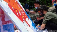 Seniman tengah menyelesaikan poster yang berisi dampak negatif dari rokok. 