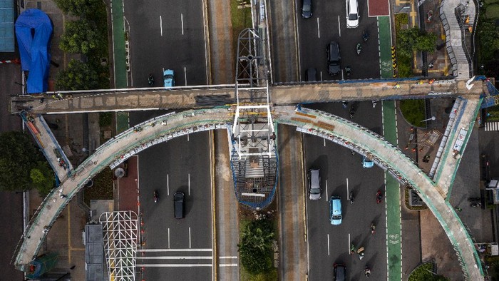 Potret Udara Revitalisasi JPO Sudirman Foto udara progres pembangunan Jembatan Penyeberangan Orang (JPO) Sudirman di Jakarta, Rabu (17/11/2021). Pemprov DKI Jakarta merevitalisasi JPO Sudirman dengan konsep menyerupai kapal pinisi yang dilengkapi jalur sepeda dan terintegrasi halte TransJakarta untuk mendukung program Jakarta ramah pejalan kaki dan ditargetkan selesai pada November 2021.ANTARA FOTO/Galih Pradipta/rwa.