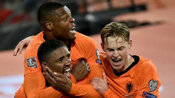 Netherlands forward Steven Bergwijn (L) celebrates with teammates after scoring his teams first goal during the FIFA World Cup Qatar 2022 qualifying round Group G football match between Netherlands and Norway at the Feijenoord stadium in Rotterdam on November 16, 2021. (Photo by JOHN THYS / AFP)