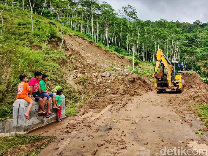 Longsor yang memutus akses jalan kabupaten di Kapanewon Girimulyo, Kulon Progo, DIY, mulai dibersihkan dengan alat berat, Kamis (18/11/2021). Alat berat itu untuk mempercepat proses pembersihan.