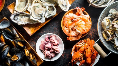 The range of different types of seafood. On dark rustic background