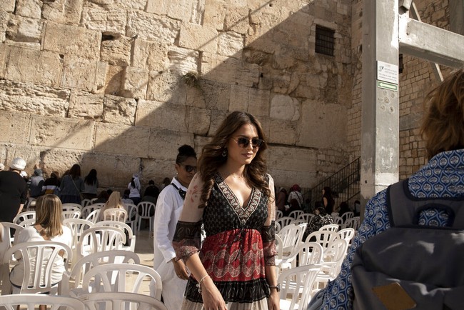 Tunic hadir dengan garis leher V yang menyumbangkan kesan seksi. Di jajaran aksesori, kacamata hitam membuat penampilannya makin bergaya. (Foto: AP/Maya Alleruzzo)