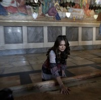 Momen Andre Meza memegang Stone of Unction di gereja Holy Sepulchre. Batu tersebut diyakini sebagai tempat dimana jasad Yesus Kristus dipersiapkan sebelum dikubur. (Foto: AP/Maya Alleruzzo)
