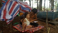 Dua anak bermain di tempat pengungsian di dalam hutan Desa Sungai Rambai, Kelurahan Mekar Jaya, Kabupaten Sintang, Kalimantan Barat.