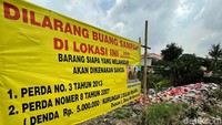 Meski telah dipasang spanduk larangan, namun sampah rumah tangga tampak menumpuk di pinggir Jalan Mangun Jaya.