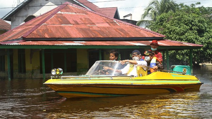 Naik Speed Boat, Menteri PUPR Tinjau Kondisi Banjir di Sintang Menteri Pekerjaan Umum dan Perumahan Rakyat (PUPR) Basuki Hadimuljono (kanan) memberikan bantuan sembako untuk korban banjir di tepian Sungai Kapuas di Sintang, Kalimantan Barat, Kamis (18/11/2021). Menteri PUPR menyatakan pihaknya siap melakukan rekayasa untuk penanganan banjir di Kabupaten Sintang, terutama menghadapi prediksi banjir besar yang akan terjadi pada Januari 2022. ANTARA FOTO/Jessica Helena Wuysang/nz