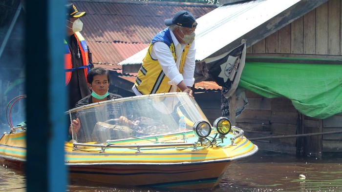 Menteri Pekerjaan Umum dan Perumahan Rakyat (PUPR) Basuki Hadimuljono (kanan) memberikan bantuan sembako untuk korban banjir di tepian Sungai Kapuas di Sintang, Kalimantan Barat, Kamis (18/11/2021). Menteri PUPR menyatakan pihaknya siap melakukan rekayasa untuk penanganan banjir di Kabupaten Sintang, terutama menghadapi prediksi banjir besar yang akan terjadi pada Januari 2022. ANTARA FOTO/Jessica Helena Wuysang/nz