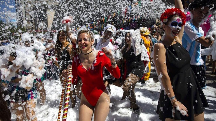 Medical school graduates dance amid foam during their class' graduation parade in Rosario, Argentina, Wednesday, Nov. 17, 2021. (AP Photo/Rodrigo Abd)
