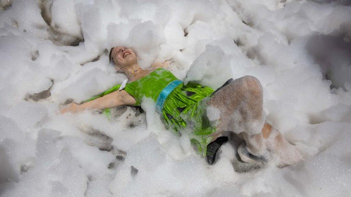 Medical school graduates dance amid foam during their class' graduation parade in Rosario, Argentina, Wednesday, Nov. 17, 2021. (AP Photo/Rodrigo Abd)