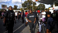 Petugas polisi Memphis menangani kerumunan di lokasi di mana rapper Young Dolph terbunuh di sebuah toko kue di Memphis. Menurut laporan media setempat, Thornton dilaporkan sedang berbelanja di toko kue Makedas Homemade Butter Cookies di Memphis pada Rabu (17/11) waktu setempat ketika seseorang pengemudi muncul menembaknya.