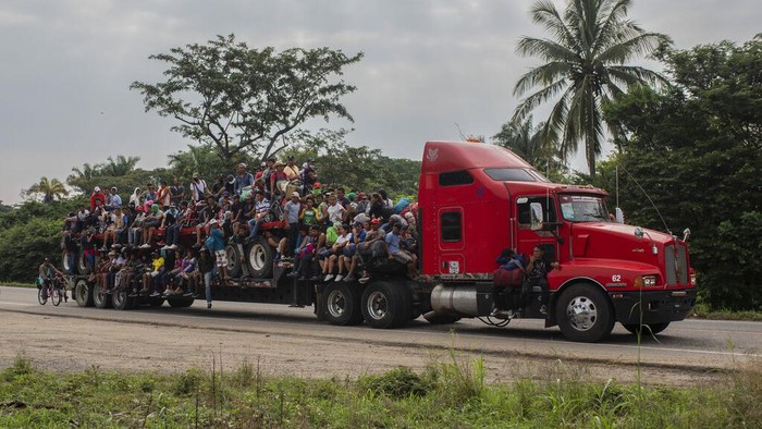 Ratusan Migran Berebut Naik Truk Demi Menuju AS A migrant child is lower from a trailer in Jesus Carranza, in the Mexican state of Veracruz, Wednesday, Nov. 17, 2021. A group of mainly Central American migrants are attempting to walk across Mexico to the U.S.-Mexico border. (AP Photo/Felix Marquez)
