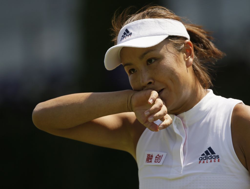 CORRECTS NAMES OF PLAYERS Peng Shuai of China wipes her face during the women's singles match against Samantha Stosur of Australia on the second day at the Wimbledon Tennis Championships in London, Tuesday July 3, 2018. (AP Photo/Tim Ireland)