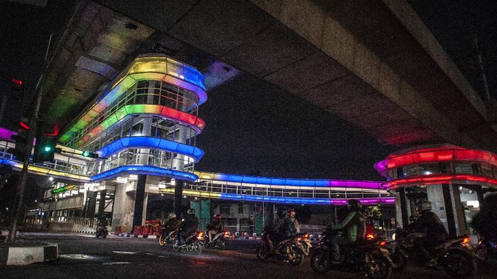 Sejumlah pengendara melintas di dekat halte Centrale Stichting Wederopbouw (CSW) yang berhiaskan lampu warna-warni di Kawasan Kebayoran Baru, Jakarta, Sabtu (31/7/2021). Proyek pembangunan jembatan penghubung atau skybridge untuk intergrasi Halte Transjakarta CSW dengan Stasiun MRT ASEAN itu mengusung konsep desain Cakra Selaras Wahana yang memiliki arti sebagai lingkaran penghubung yang setara antar moda. ANTARA FOTO/Aprillio Akbar/wsj.