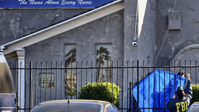 FILE - FBI agents cover a fence on the grounds of the Kingdom of Jesus Christ Church in the Van Nuys section of Los Angeles on Jan. 29, 2020. Apollo Carreon Quiboloy, the leader of the Philippines-based church was charged with having sex with women and underage girls who faced threats of abuse and “eternal damnation” unless they catered to the self-proclaimed “son of God,