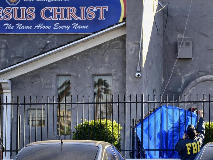 FILE - FBI agents cover a fence on the grounds of the Kingdom of Jesus Christ Church in the Van Nuys section of Los Angeles on Jan. 29, 2020. Apollo Carreon Quiboloy, the leader of the Philippines-based church was charged with having sex with women and underage girls who faced threats of abuse and “eternal damnation” unless they catered to the self-proclaimed “son of God,