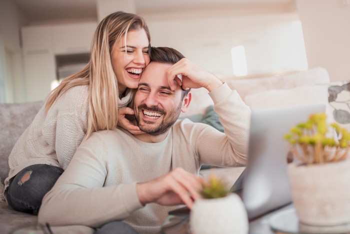 ilustrasi pasangan Close up of young couple working on laptop at home.