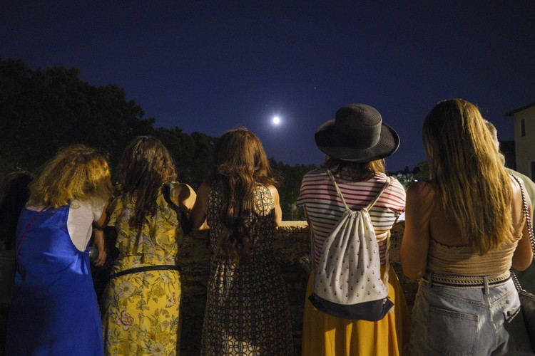 People watch a rising full moon during a partial lunar eclipse, in Rome, late Tuesday night, July 16, 2019. The eclipse coincides with the 50th anniversary of the launch, on July 16, 1969, of the Apollo 11 mission that landed the first men on the moon. (AP Photo/Andrew Medichini)