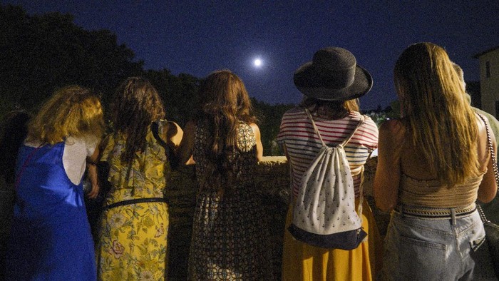 People watch a rising full moon during a partial lunar eclipse, in Rome, late Tuesday night, July 16, 2019. The eclipse coincides with the 50th anniversary of the launch, on July 16, 1969, of the Apollo 11 mission that landed the first men on the moon. (AP Photo/Andrew Medichini)