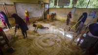 Para murid membersihkan ruang kelas SD Negeri Hantakan yang dipenuhi lumpur akibat meluapnya sungai Hantakan.