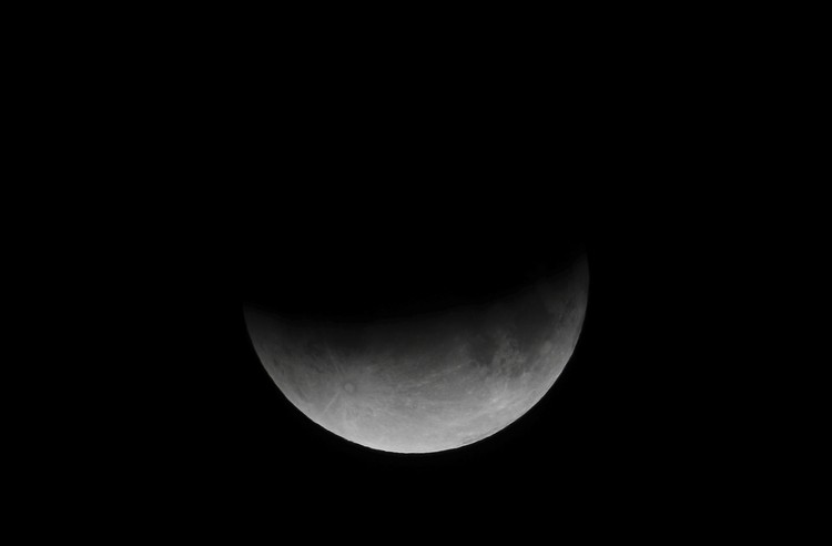 The Week That Was in Latin America Photo Gallery I this Tuesday, July 16, 2019 photo, men stand below street lights as the moon rises during a partial lunar eclipse in Buenos Aires, Argentina. (AP Photo/Natacha Pisarenko)