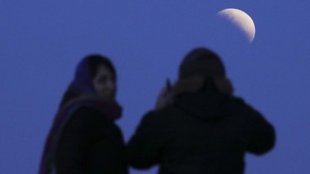 Sepasang kekasih menyaksikan gerhana Bulan sebagian, di Buenos Aires, Argentina, Selasa, 16 Juli 2019. Foto: AP/Natacha Pisarenko