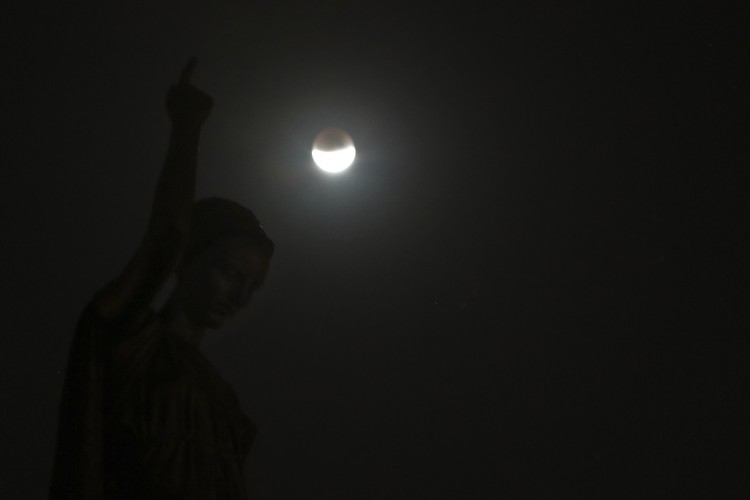 The Week That Was in Latin America Photo Gallery I this Tuesday, July 16, 2019 photo, men stand below street lights as the moon rises during a partial lunar eclipse in Buenos Aires, Argentina. (AP Photo/Natacha Pisarenko)