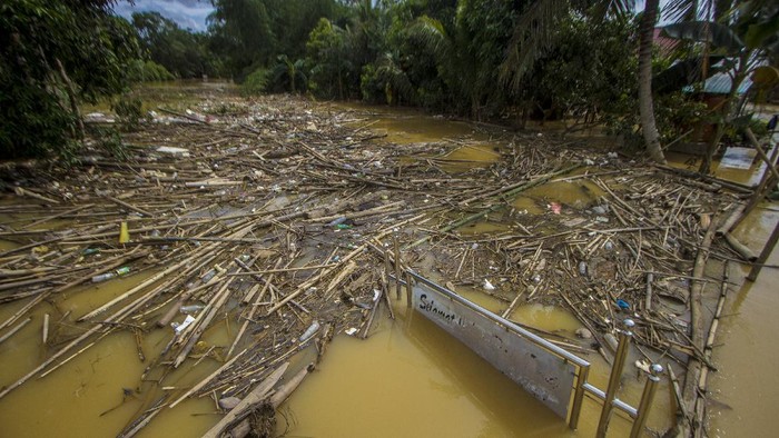 BANJIR DI KABUPATEN HULU SUNGAI TENGAH Warga menggunakan rakit bambu melintasi banjir yang merendam permukiman di Desa Masiraan, Kabupaten Hulu Sungai Tengah, Kalimantan Selatan, Sabtu (20/11/2021). Banjir telah merendam desa tersebut selama sepekan terakhir. ANTARA FOTO/Bayu Pratama S/foc.